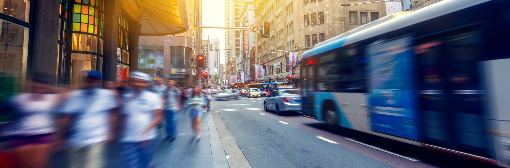 Busy CBD street with bus and commuters. Presenter image overlayed: Simon Hunter, Paul Glucina, Allison Heller.