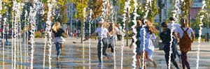 Children funning through city water feature. Presenter images overlayed: Tiffany Crawford, Krista Milne, Michael Nolan.